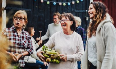 Three women, smiling, talking and laughing at a farmer's market